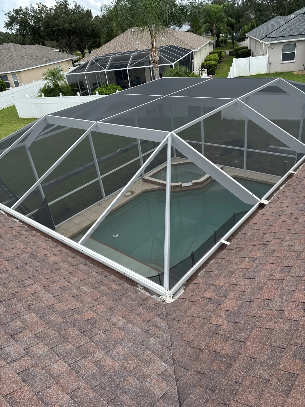 Roof-level view of the renewed white pool enclosure with new screening